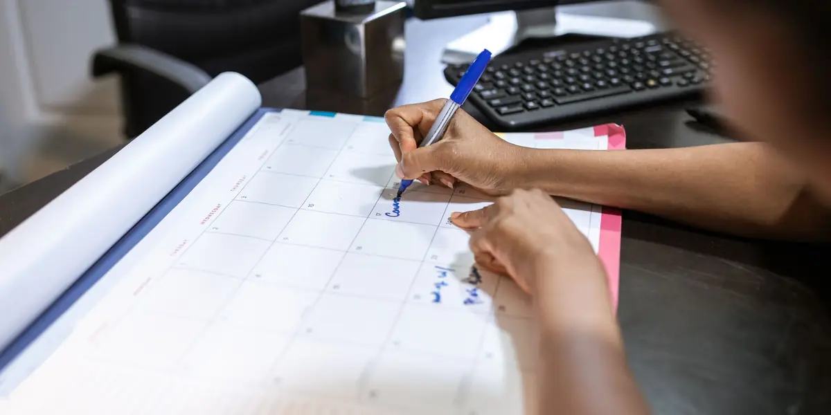 Appointments being written into a desk calendar