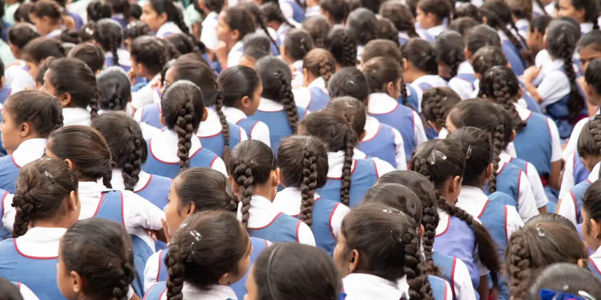 Students in uniform sitting in a classroom, seen from behind