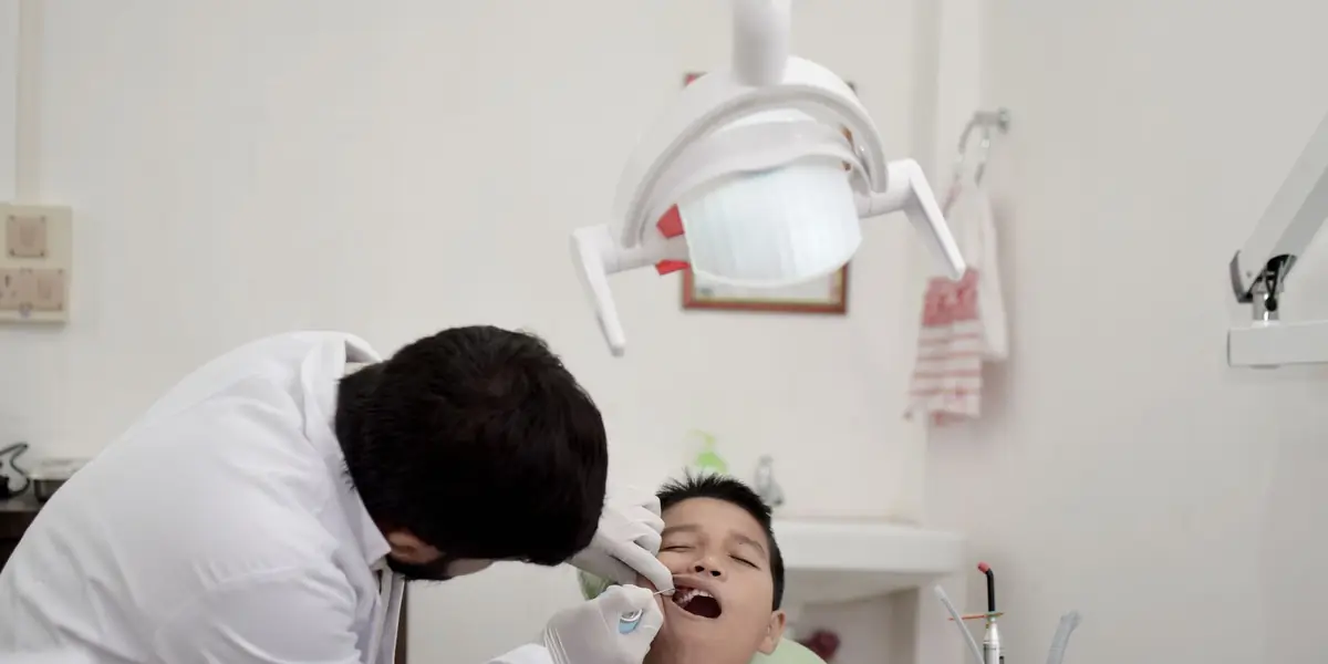 A dentist examining a young patient in a dental clinic