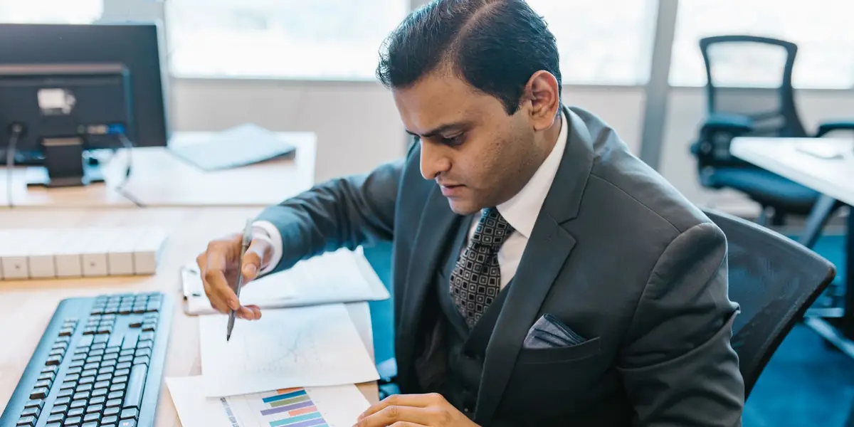 A financial adviser reviewing charts at his desk