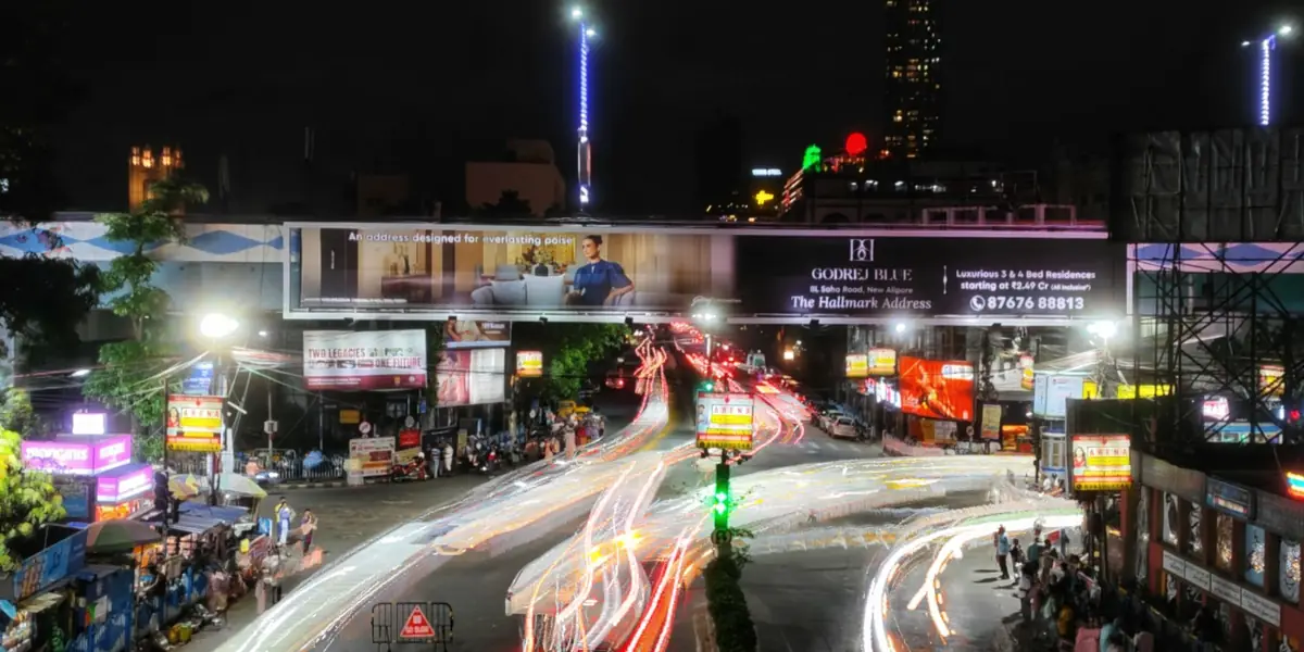 An Indian city street at night, traffic still moving