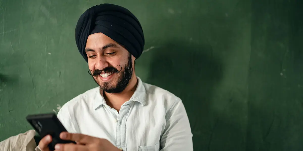A man smiling at a message on his phone
