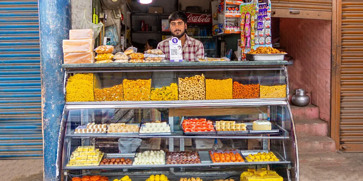 A sweet shop counter with the owner behind it