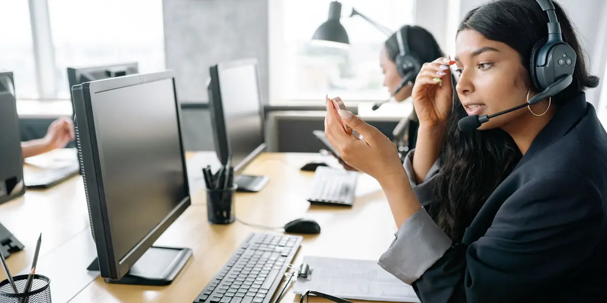 A support agent with a headset at her workstation