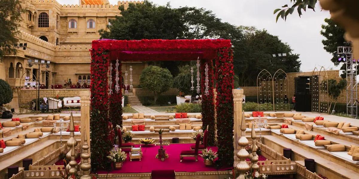 A wedding mandap set up outdoors beside a heritage building